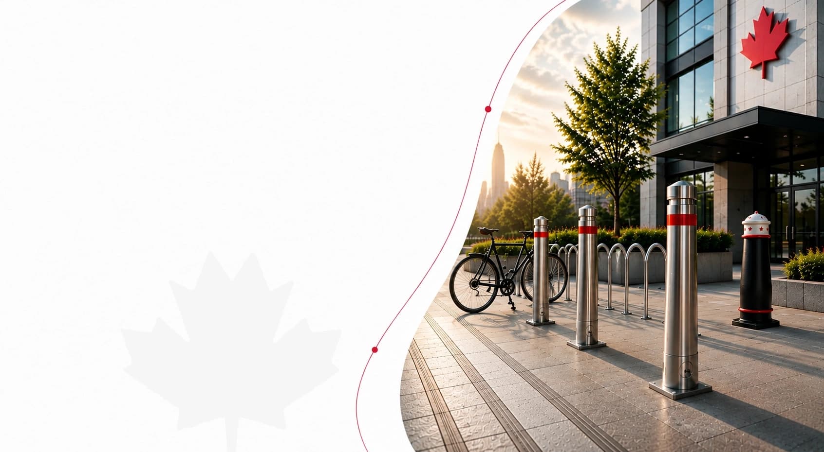 Stainless bollards with red bands, a bike rack and a decorative black bollard outside a Toronto commercial building at sunset
