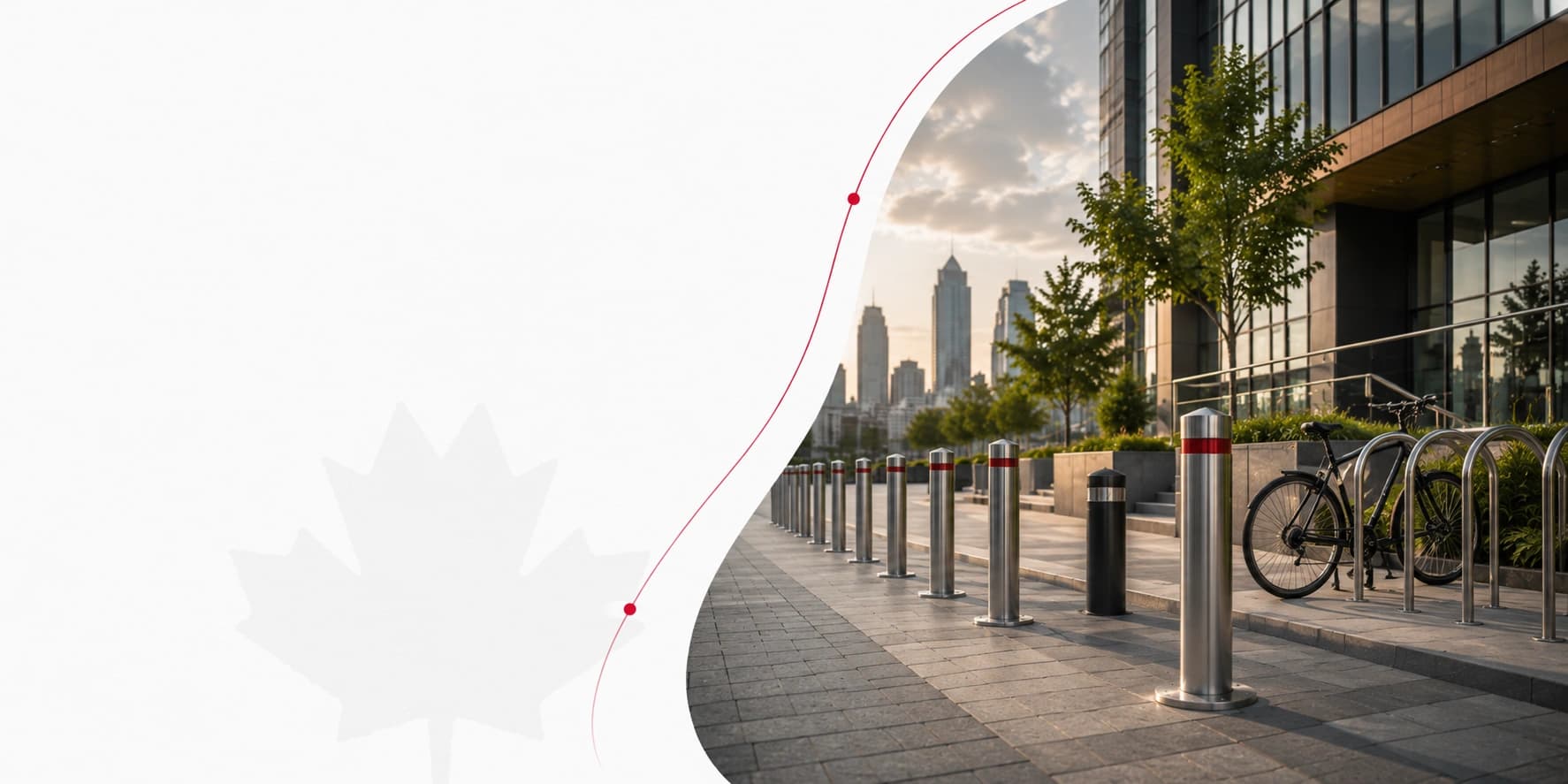 Stainless bollards with red bands and a bike rack along a downtown Toronto office frontage at sunset